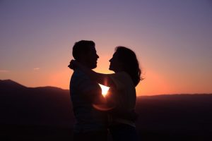 This couple has made it! Your retirement readiness begins here. A silhouette, setting sun in distance, of husband and wife in loose embrace looking into each others eyes